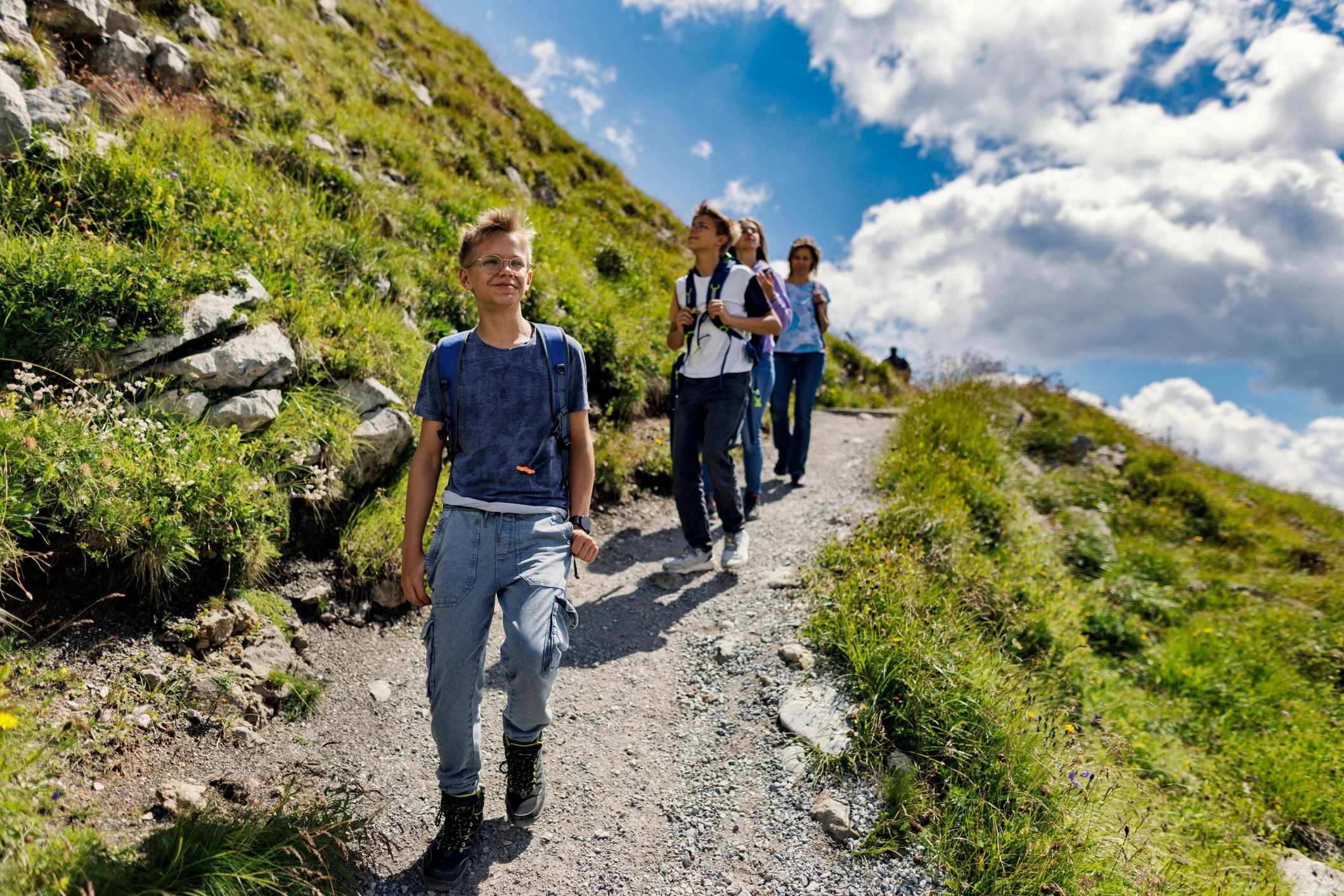Hikers walking along a scenic alpine trail