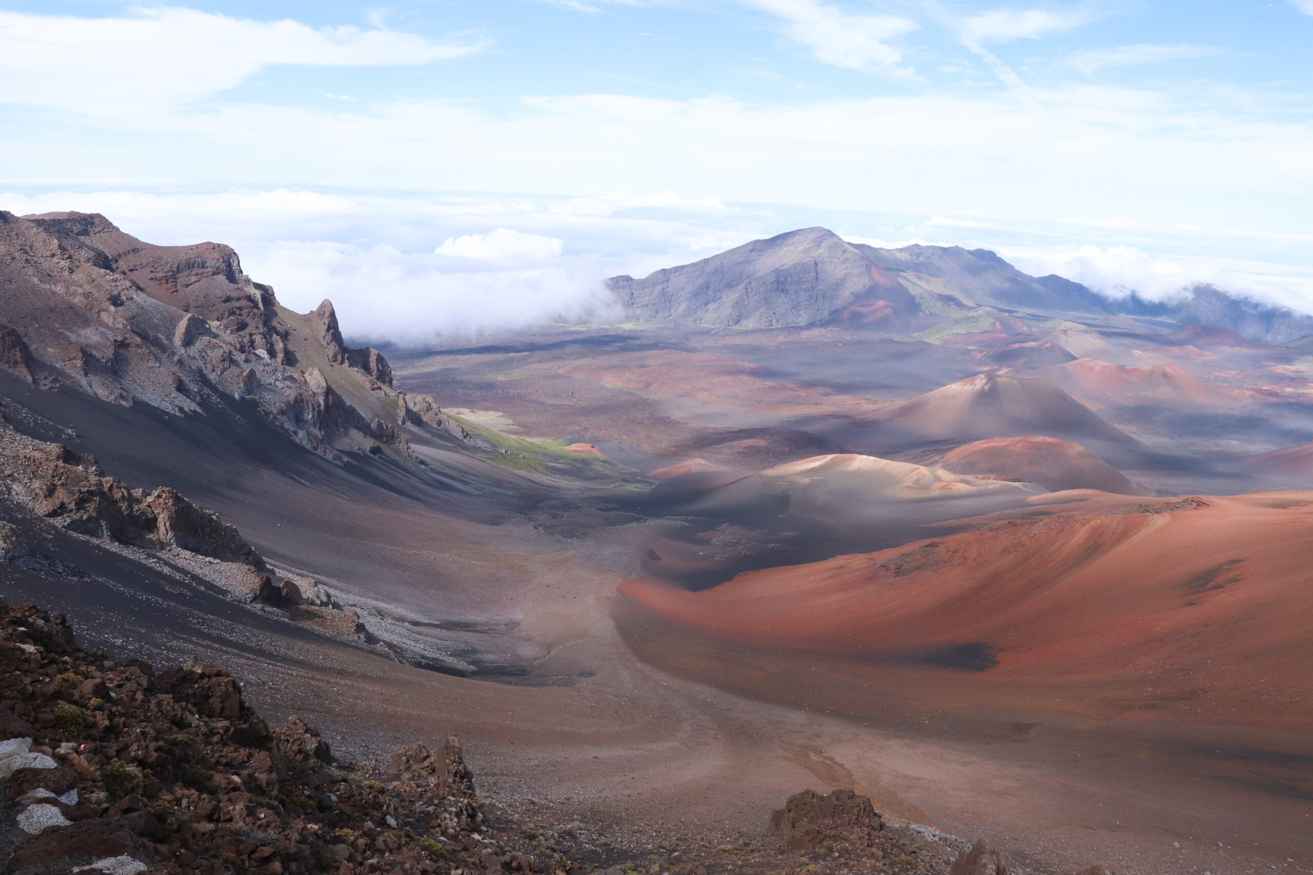 Haleakalā on the island of Maui Hawaii — Hale-a-ka-lā House of the Sun — the dormant shield volcano forming three-quarters of Maui at 10023 feet elevation with the dramatic 7.5-mile-long erosional crater depression on the summit and views across the Pacific to neighboring Hawaiian islands