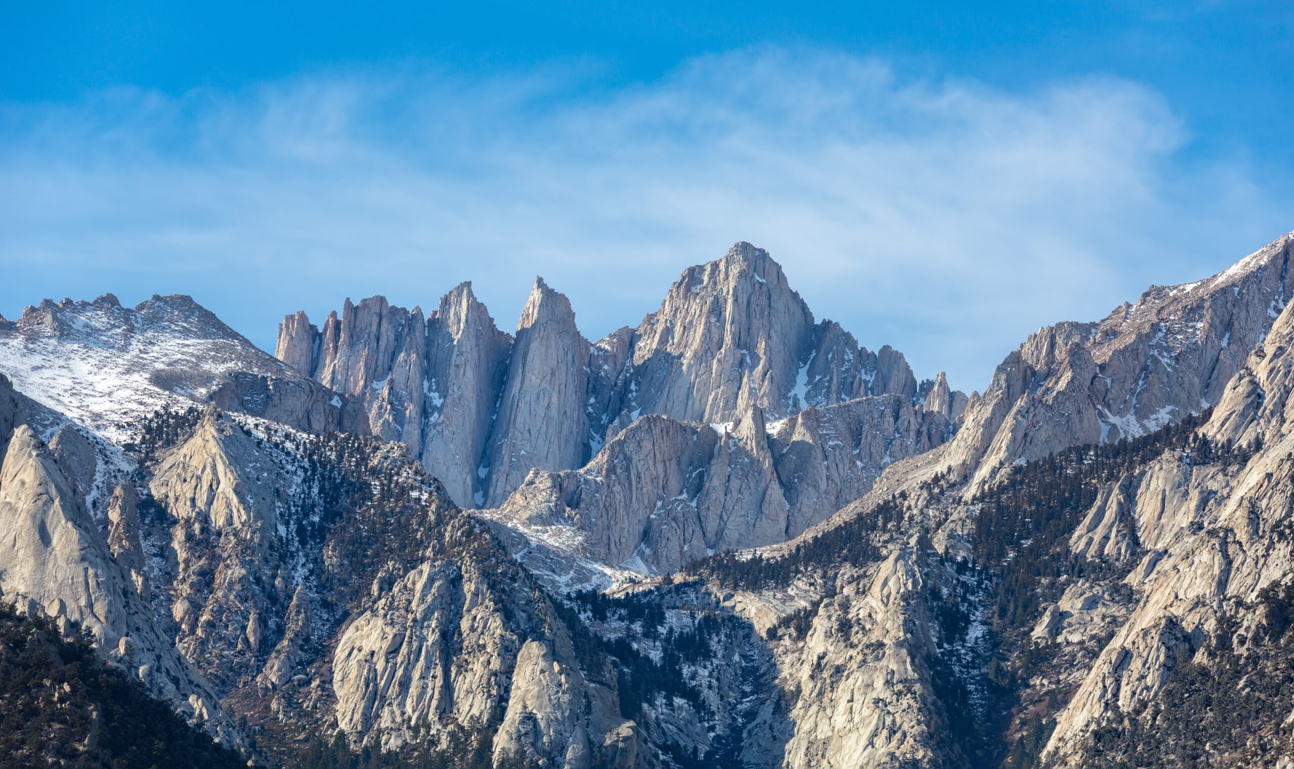 Mount Whitney at 14505 feet in the Sierra Nevada of California USA viewed from Alabama Hills near Lone Pine showing the iconic granite ridge and peaks of the highest mountain in the contiguous United States first climbed on 18 August 1873 by Lone Pine fishermen Charles Begole Albert Johnson and John Lucas