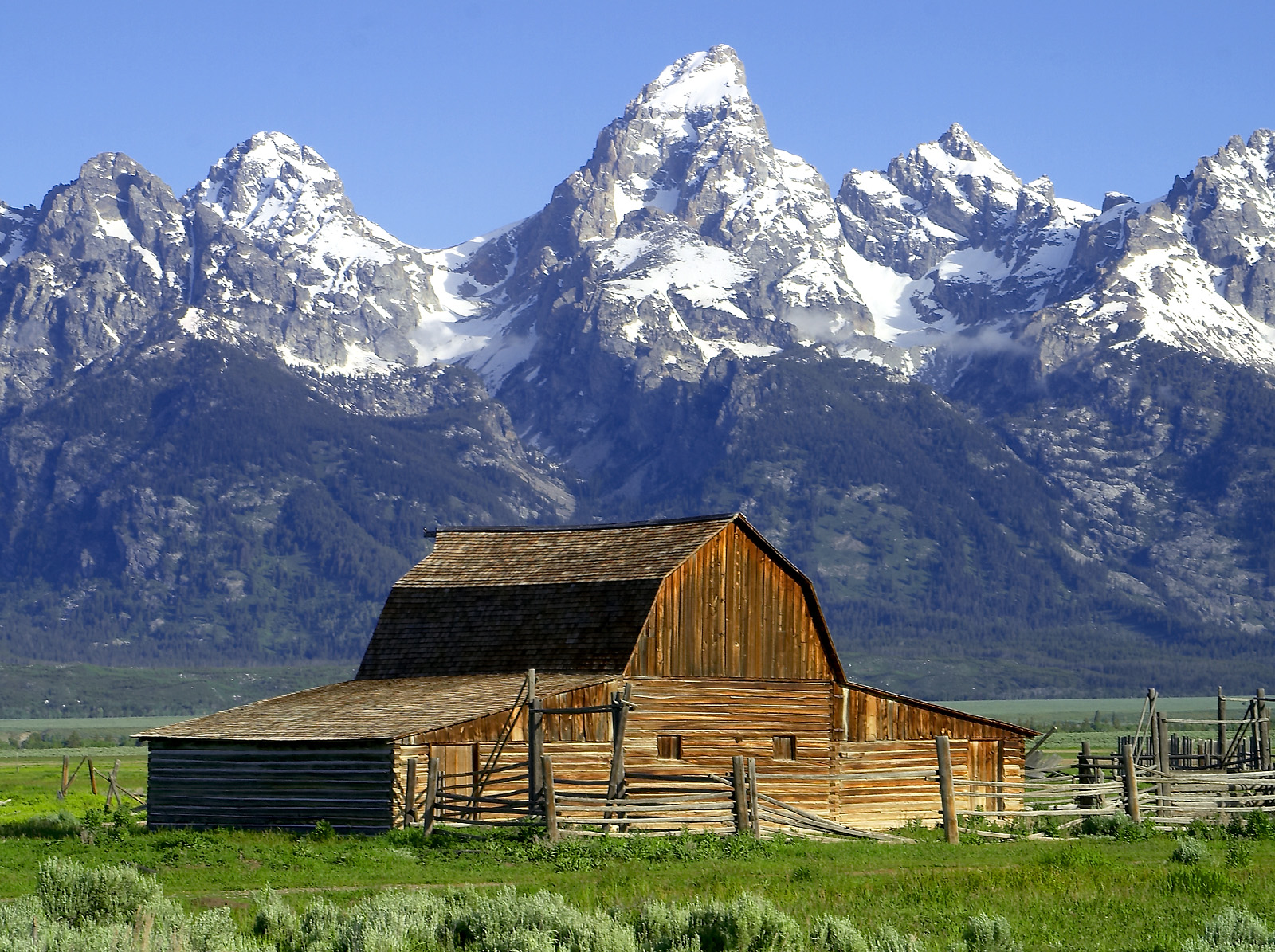 Grand Teton mountain range viewed from Mormon Row barns, Wyoming.