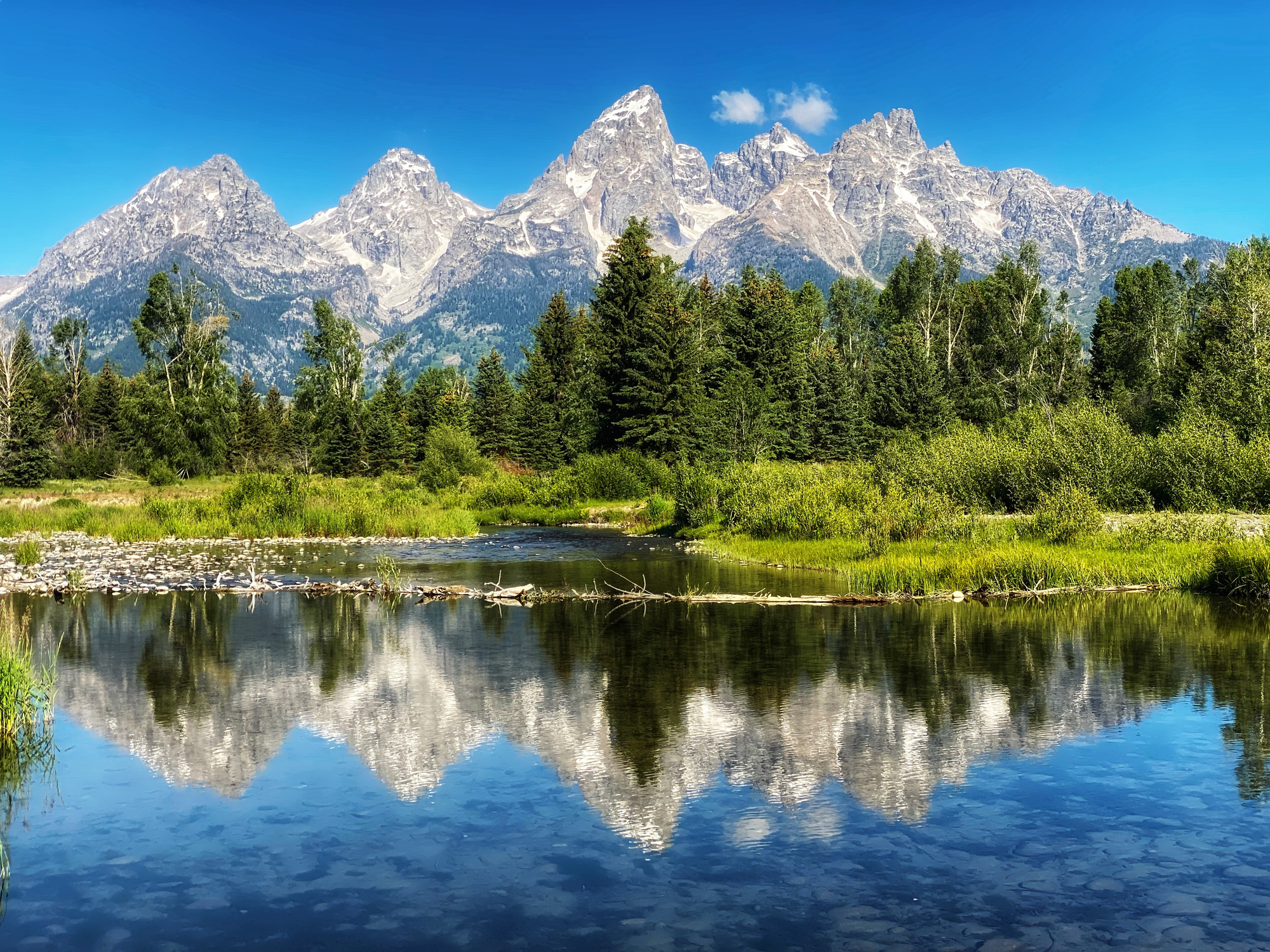 Grand Teton dramatic mountain peak representing the expedition-grade alpine objectives that define expert mountaineering territory where Class 4 to Class 5 technical rock climbing combines with weather exposure altitude effects and multi-day commitment to demand the full expert skill set including fixed line technique rope team coordination crevasse rescue capability advanced gear systems including double mountaineering boots expedition packs and -40 degree sleeping systems extreme altitude physiology understanding HACE HAPE recognition operator-team dependency permit logistics and managing objective hazard that cannot be eliminated through skill alone marking the qualitative shift from intermediate single-day or weekend objectives toward multi-week expedition operations on peaks like Denali Aconcagua Cho Oyu Mera Peak Island Peak and ultimately Everest
