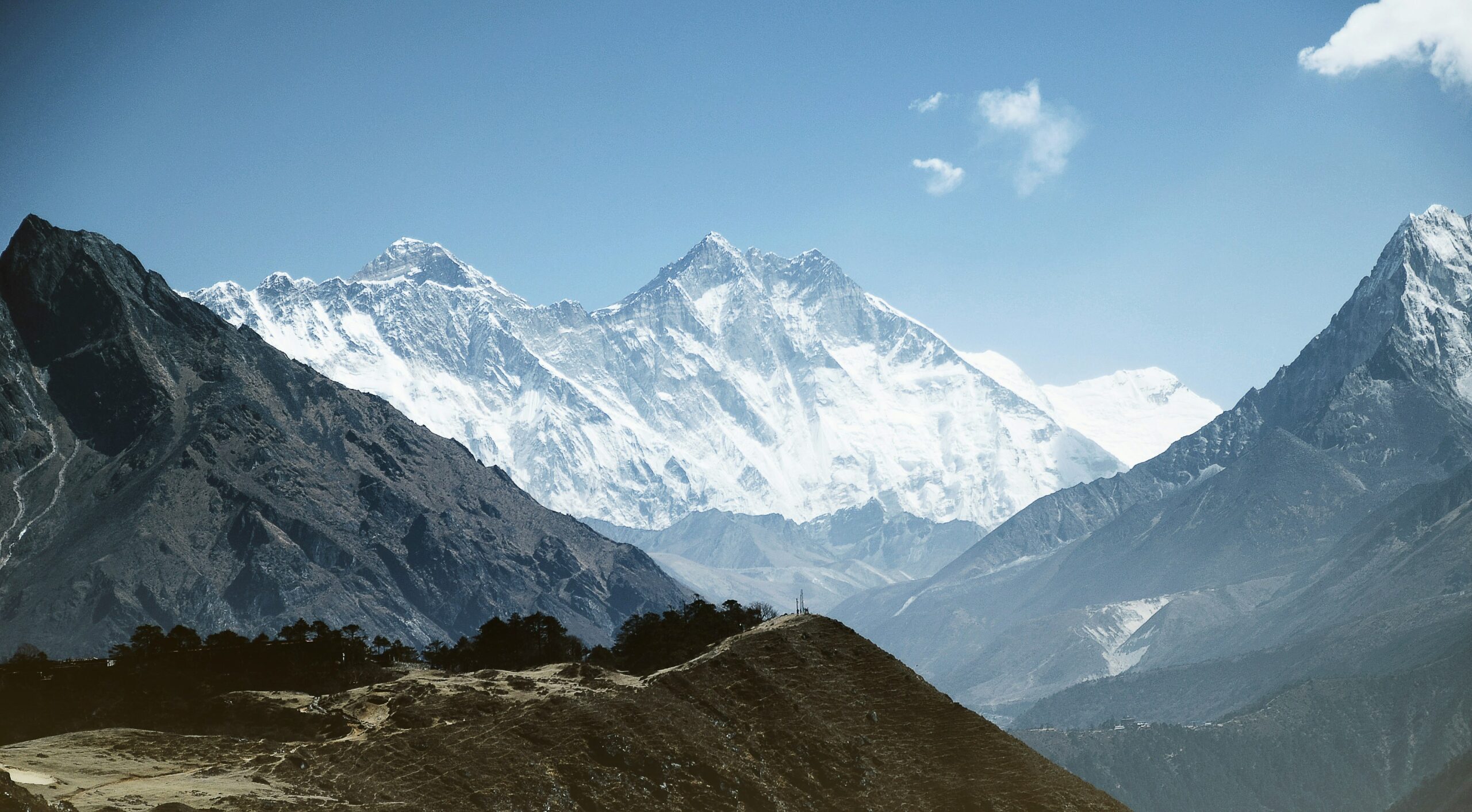 Majestic view of Mount Everest and surrounding peaks, showcasing the rugged terrain and snow-capped mountains, relevant to climbing routes and expedition planning.