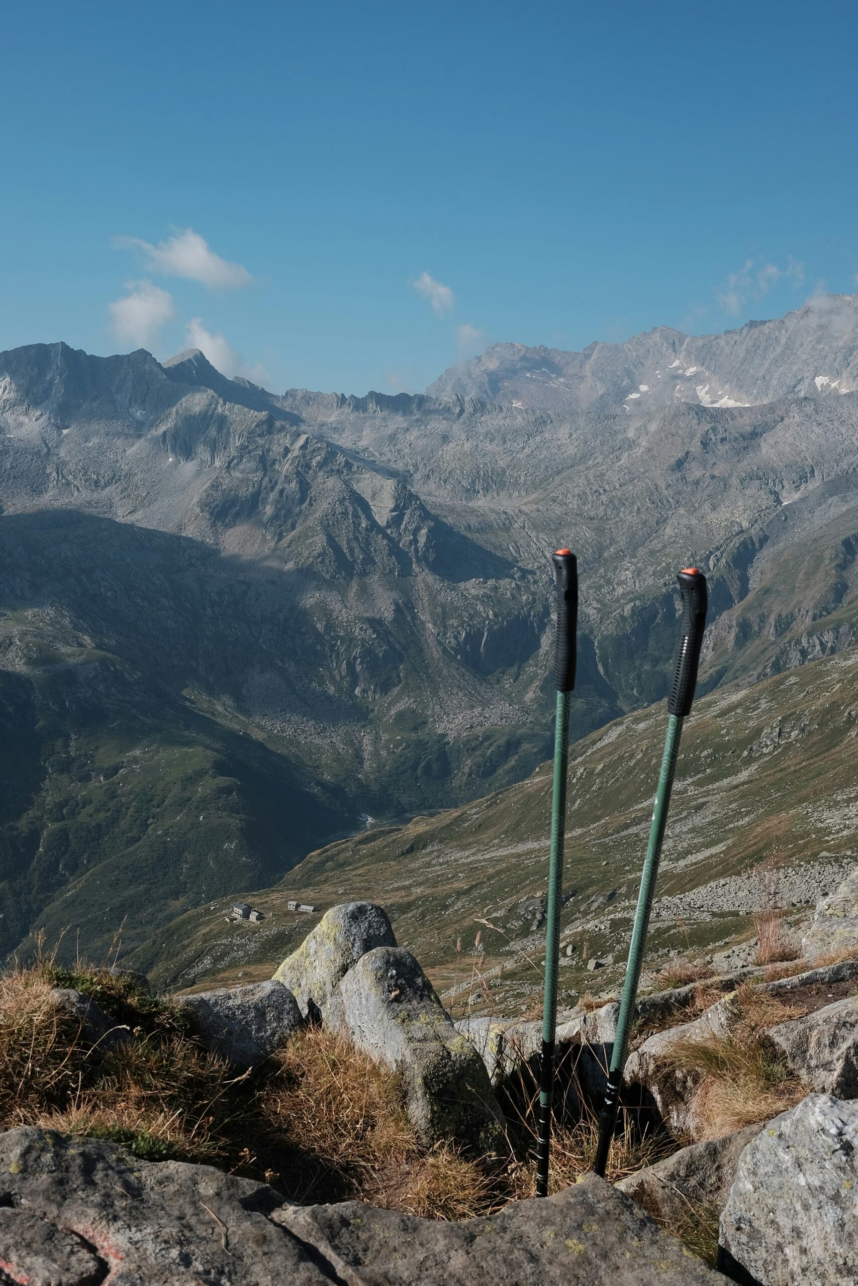 Trekking poles positioned on rocky terrain with a mountainous landscape in the background, highlighting outdoor adventure and hiking gear for 2026.