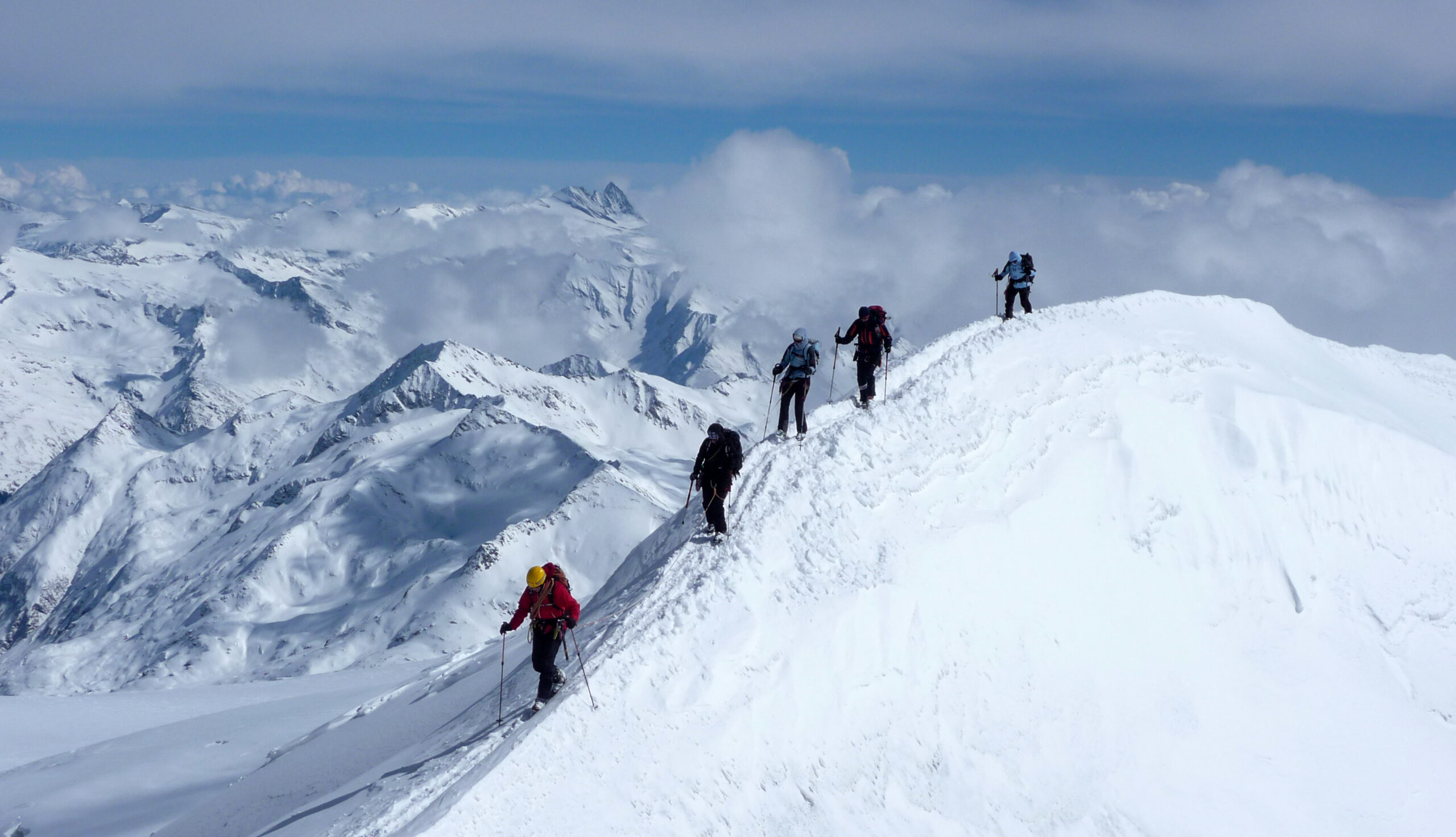 A small mountaineering team traveling together through alpine terrain