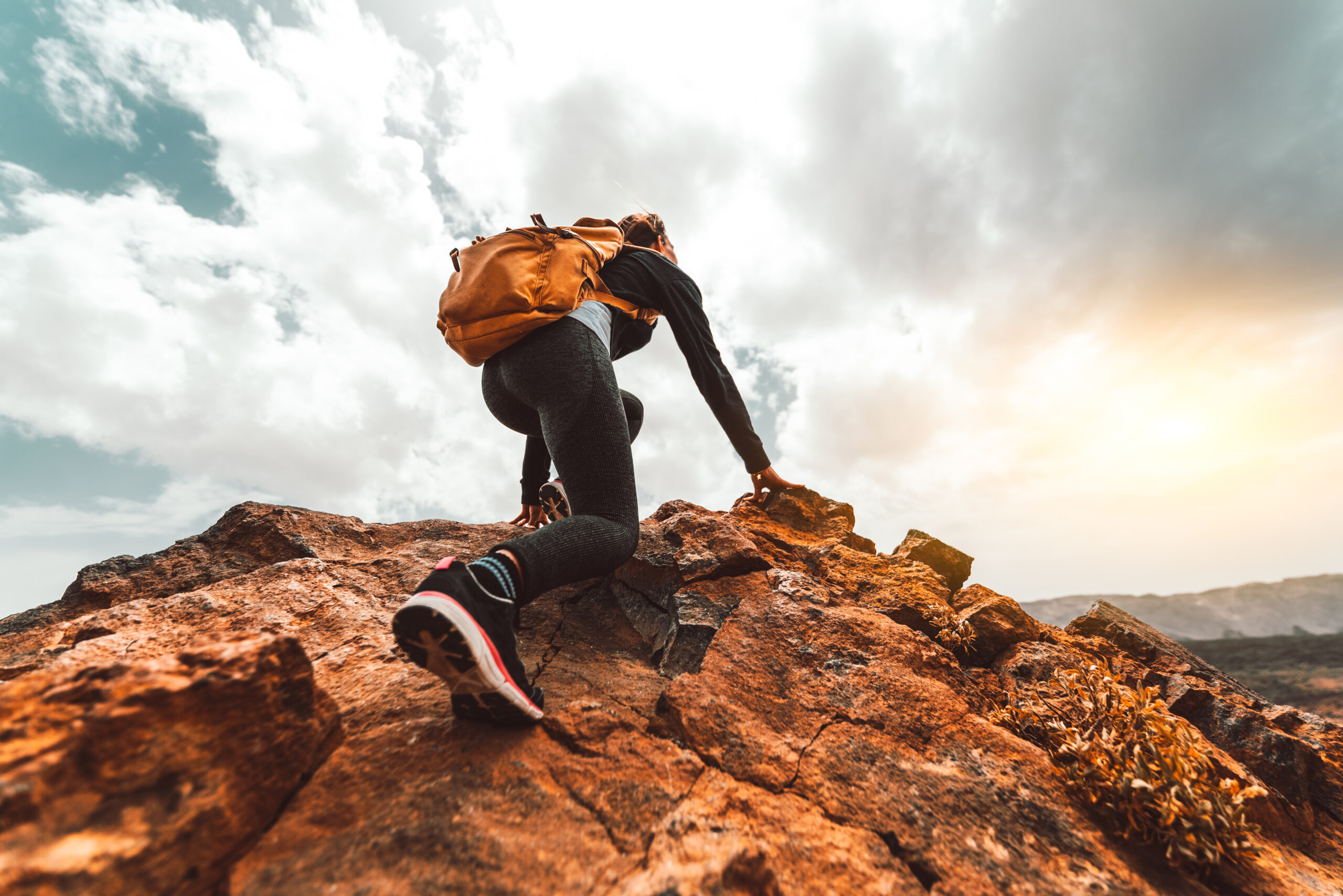 Hiker on a mountain peak at sunrise after a pre-dawn start