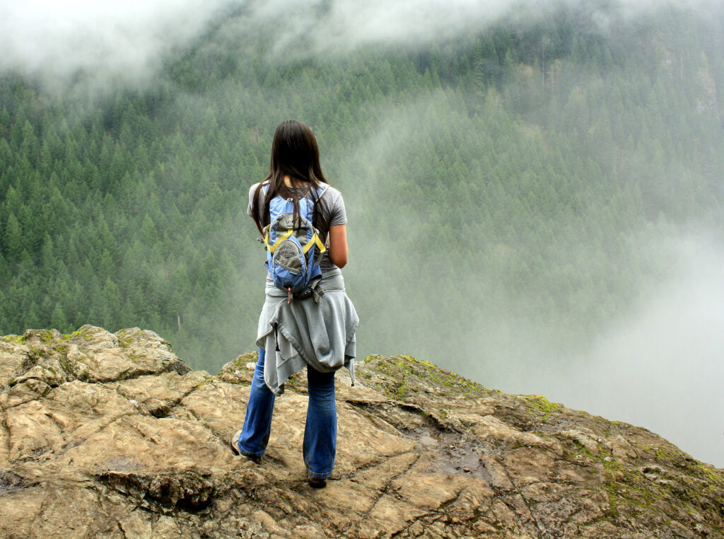 Hiker on an approachable mountain trail representing a first summit