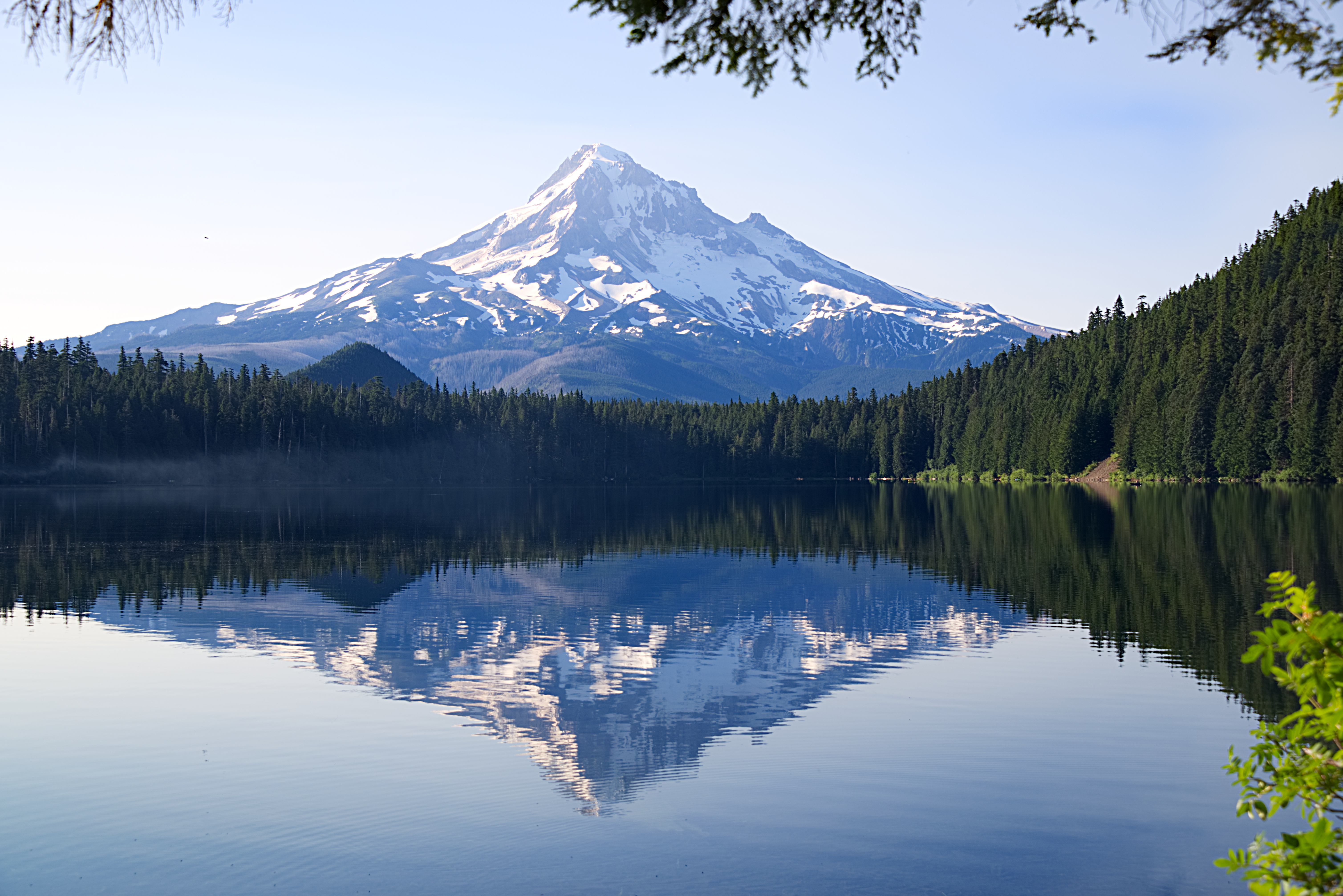 Snow-capped Mount Hood reflected in a calm lake, Oregon Cascade volcano climbing destination.