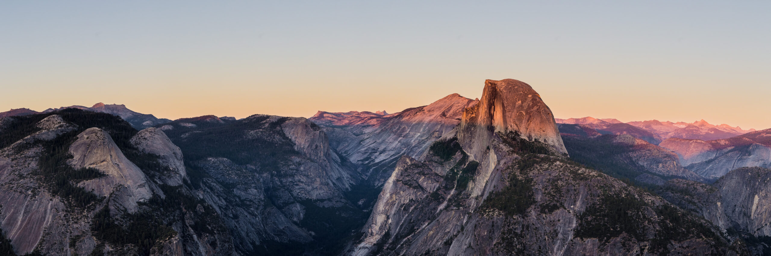 California Sierra Nevada mountain landscape representing the two most iconic California day hikes Half Dome at 8839 feet elevation in Yosemite National Park with its famous cables section on the steep granite subdome and Mount Whitney at 14505 feet elevation the highest peak in the contiguous Lower 48 United States both located in California's Sierra Nevada range both requiring Recreation.gov permit lotteries and both attracting hundreds of thousands of permit applications annually with the comparison representing the central question California hikers face about which iconic objective to tackle first