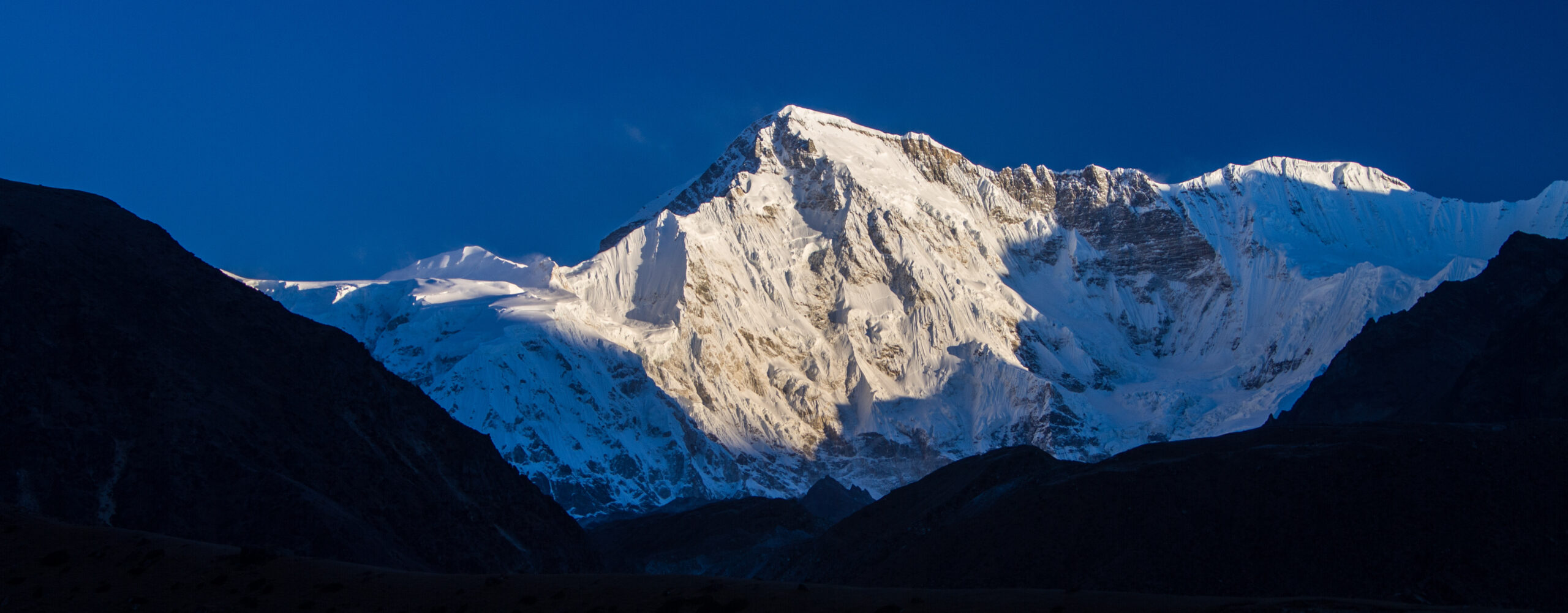 Cho Oyu mountain peak illuminated by sunlight, illustrating 8000-meter expeditions and operator choices.
