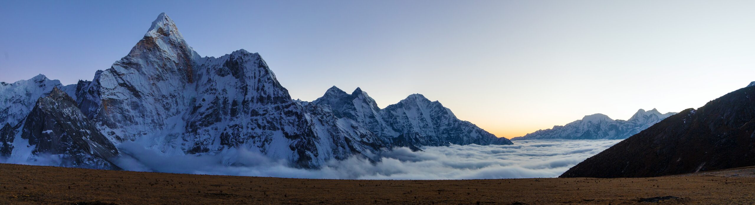 Climbers on Ama Dablam's exposed Southwest Ridge with fixed ropes and the Khumbu Himal behind