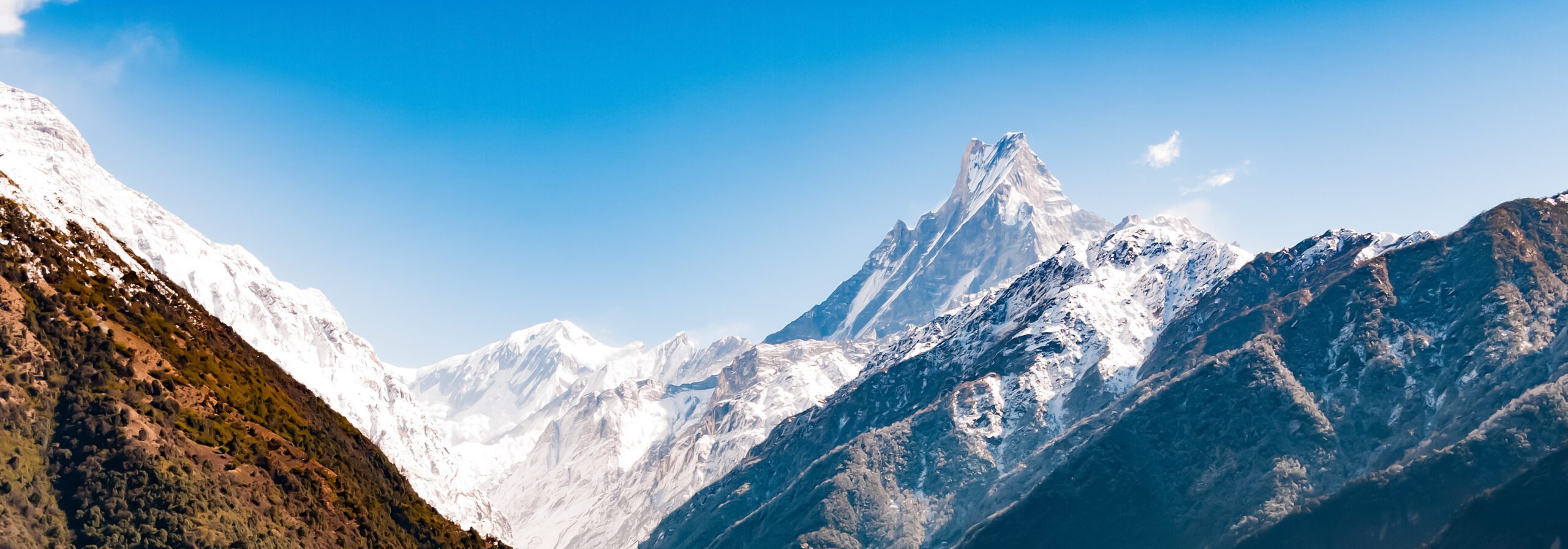 Machapuchare, the sacred 6,993m Fishtail peak of the Annapurna Sanctuary in Nepal, its sharp twin summit rising against the Himalayan sky