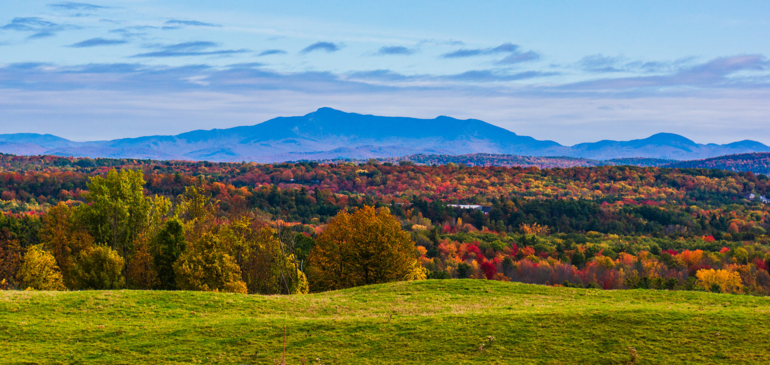 Vermont mountain landscape with vibrant fall foliage and scenic overlook.