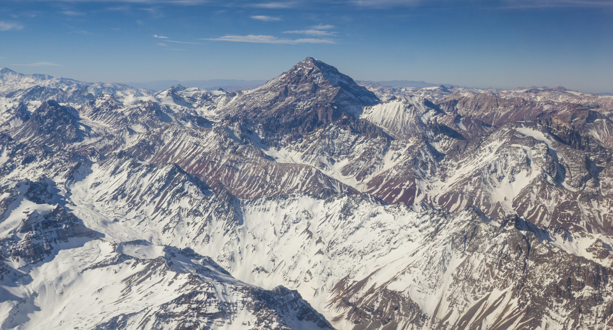 Aconcagua Normal Route summit ridge approach showing the characteristic Andes high-altitude landscape with the Canaleta final 400 meter summit gully ascending from approximately 6500 meters to 6961 meters at sustained 30 to 40 degree gradient consisting of loose scree and moderate snow patches with the Camp Cólera high camp at 6000 meters positioned at the base of the Canaleta final summit climb requiring 8 to 12 hour round trip summit push days in 50 to 100 kilometer per hour sustained winds during the December to February austral summer climbing season plus the strict 5pm summit day turnaround rule accounting for the 6 to 8 hour descent from summit to Camp Cólera and the increasing Viento Blanco white wind probability after dark with the Aconcagua Provincial Park rangers and the AAGM-certified Argentine specialist operators enforcing the canonical summit safety culture on South America's highest peak