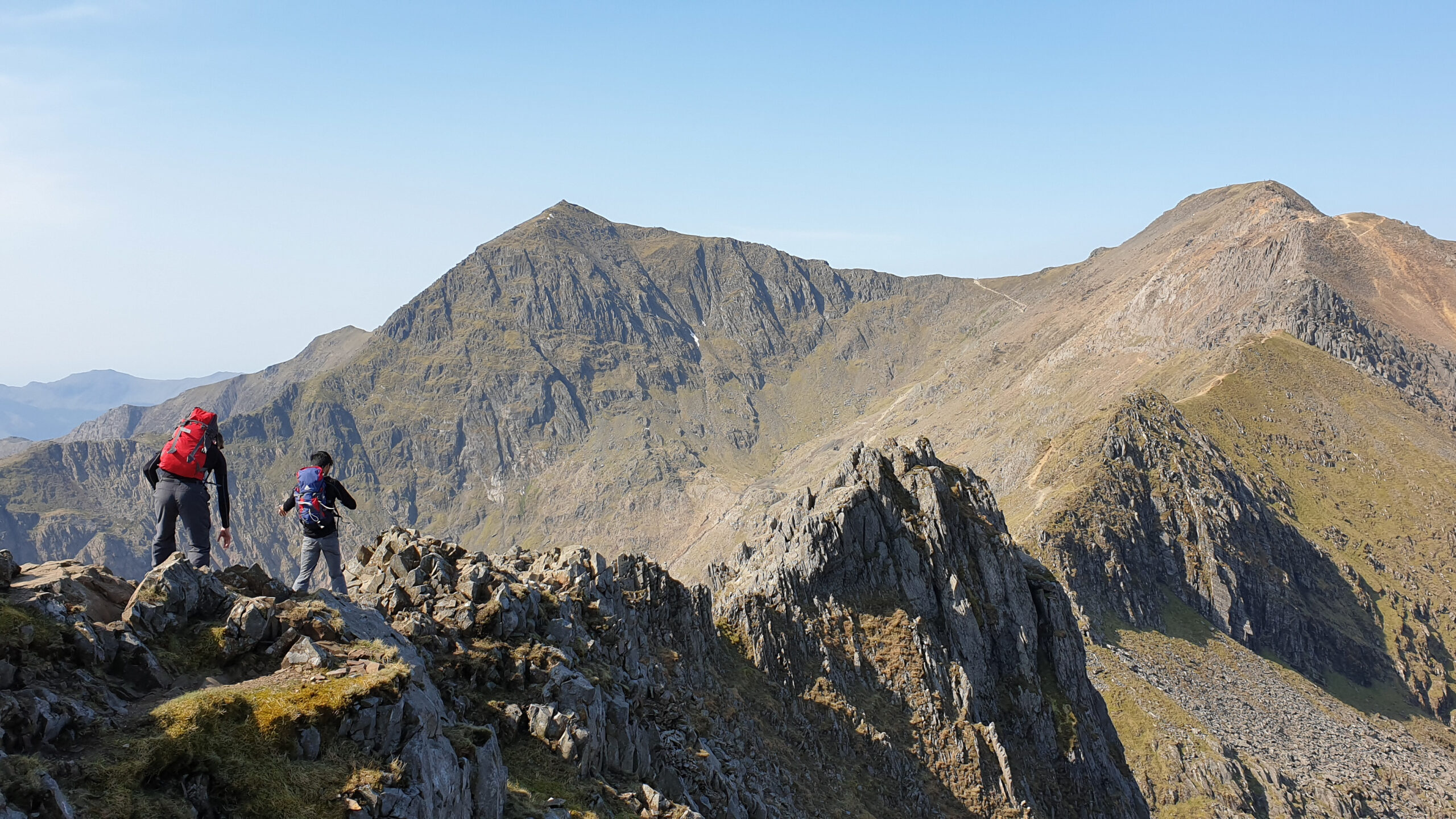 The trials and tribulations of Crib Goch the famous Grade 1 scramble knife-edge ridge on Snowdon (Yr Wyddfa) in Snowdonia National Park Wales showing the exposed rocky ridgeline that connects to the 1085 meter summit of the highest peak in Wales and represents one of the most committing and technical routes on a British Isles peak with significant exposure requiring scrambling skills and a head for heights demonstrating why Snowdon offers far more than the standard Llanberis Path with multiple ascent routes from gentle to genuinely committing for experienced hill walkers