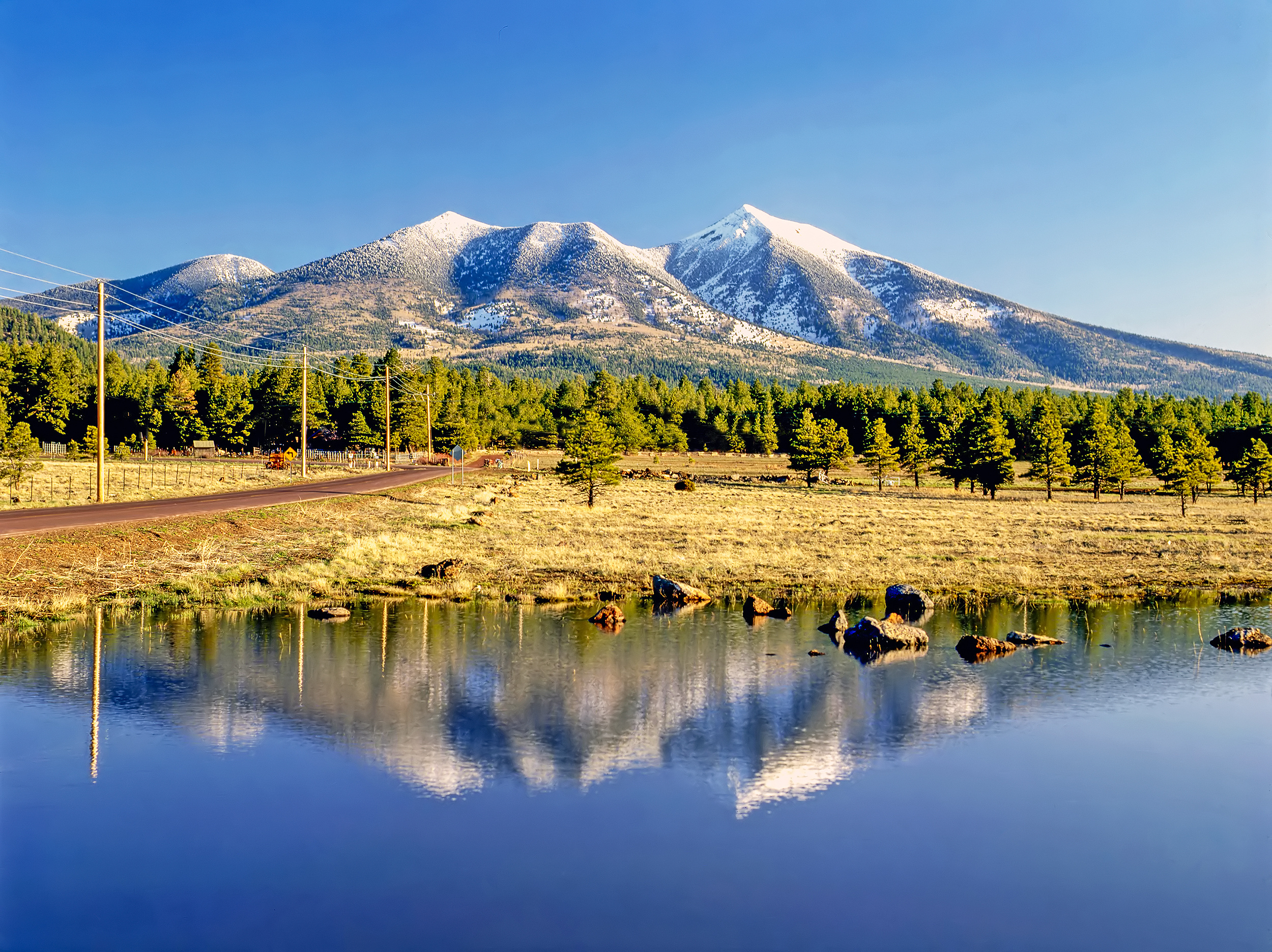 Snow-capped Arizona mountains reflected in a pond, alpine zone landscape and White Mountains scenery.