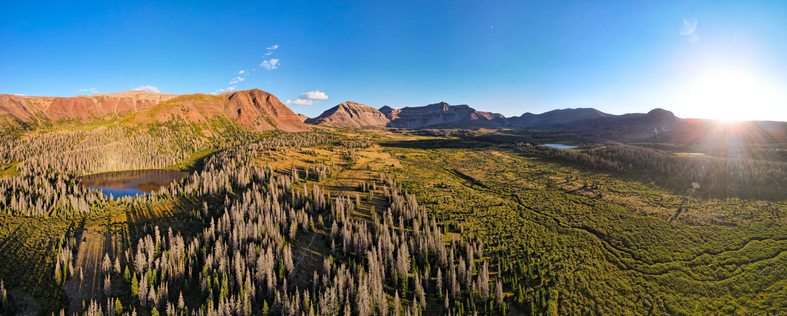 Dramatic landscape view of Kings Peak in the Uinta Mountains of northeastern Utah showing the alpine terrain of the High Uintas Wilderness Area which is the only major east-west running mountain range in the continental United States with the 13528 foot summit and surrounding alpine basins including Henrys Fork Basin and Dollar Lake camping areas at approximately 10800 to 11200 feet elevation demonstrating the remote backpacking character of Utah's state highpoint requiring a 28.8 mile round trip from the Henrys Fork Trailhead typically completed as a 2 to 3 day backpacking trip with Class 2 scrambling on the final summit ridge