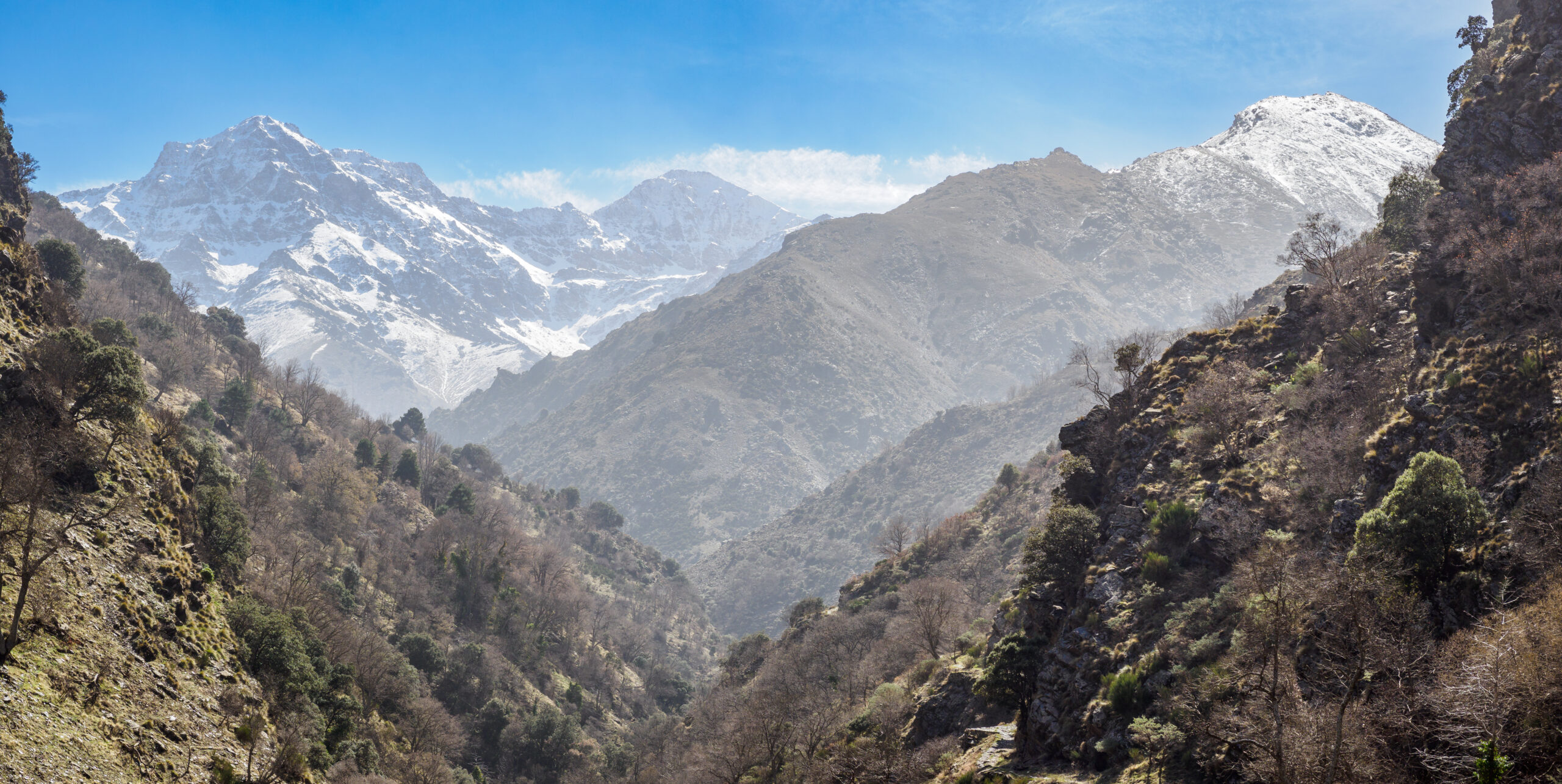 Snow-capped Mulhacén peak and Sierra Nevada mountains viewed from a hiking trail in Spain