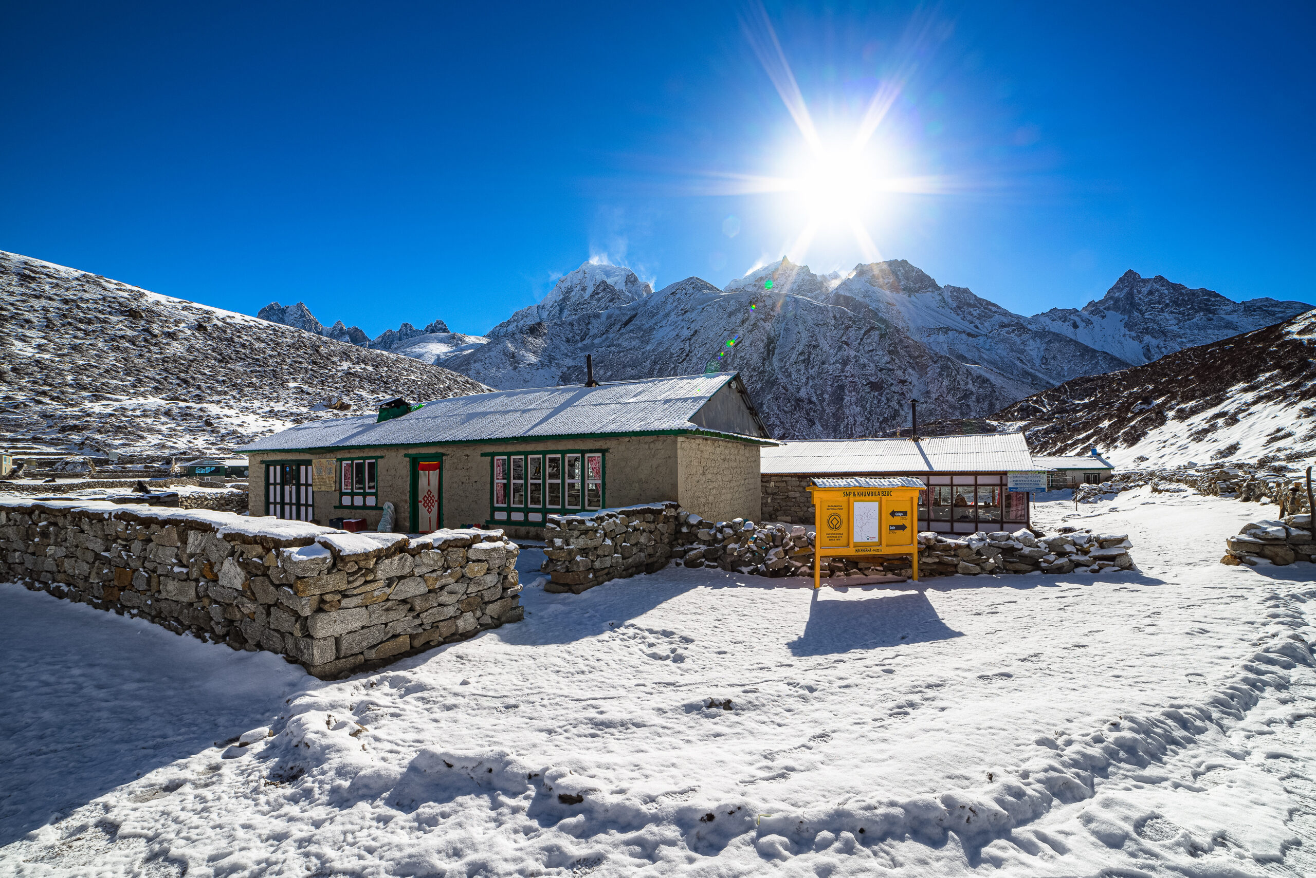 Trekkers crossing a high mountain pass on a high-altitude circuit under snow peaks